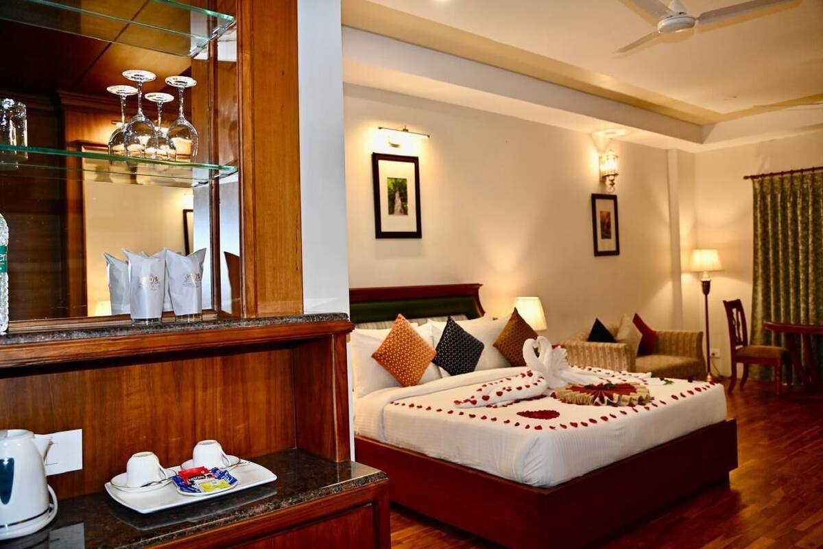 A hotel room with a bed, bedside table, and a mirror.