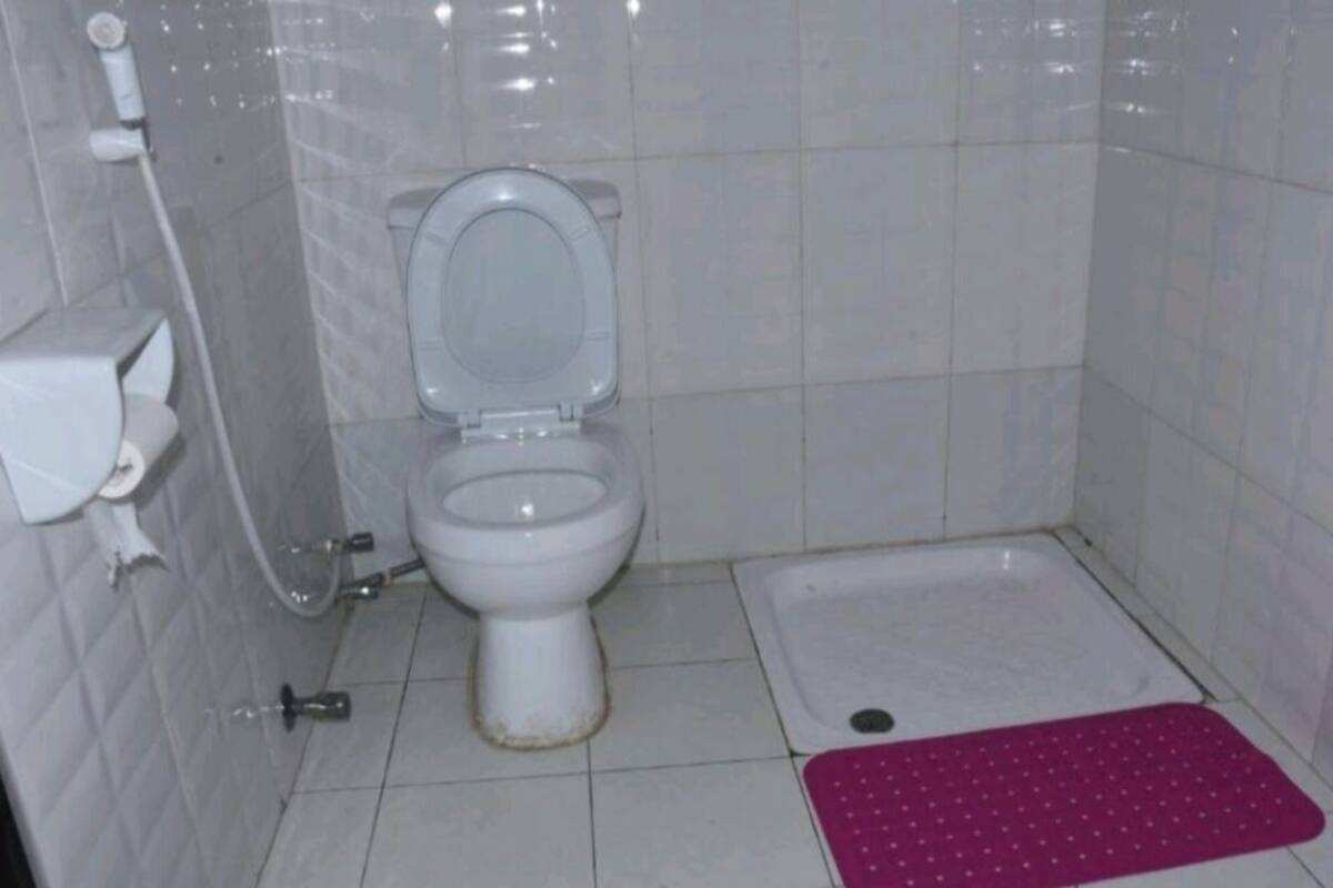 Ein kleines Badezimmer mit Fliesen, einer Toilette, einem Bidet und einer Duschkabine.