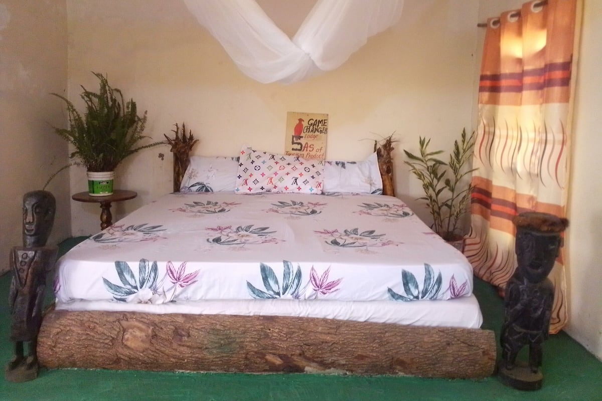 A bed with a floral bedspread, a canopy, and a sign on the wall.