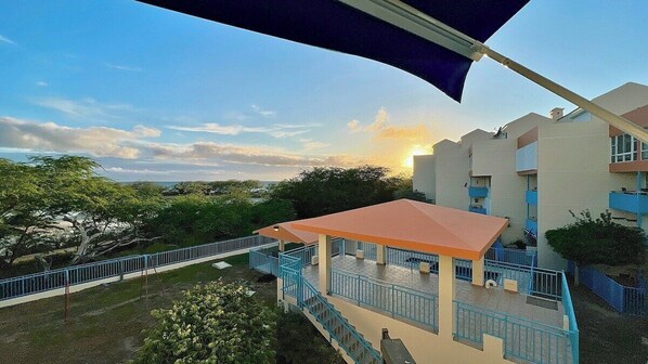 A building with a covered outdoor area, a staircase, and a view of the surrounding landscape.