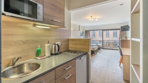 A modern kitchen with a built-in microwave, stainless steel sink, and a compact dishwasher. - Room-value Stay Residence Mechelen - Stu (Mechelen)