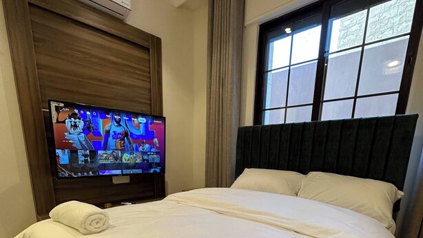 Une chambre d’hôtel avec un lit, une télévision et une fenêtre.