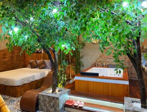 A bedroom with a bed, a wooden headboard, a large window, and a bathroom with a bathtub and a sink. - OYO 1214 Hoang Gia Athena Hotel (Hue)