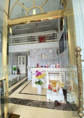 A hotel lobby with a marble floor, a reception desk, a chandelier, and a balcony with ornate railings. - OYO 1214 Hoang Gia Athena Hotel (Hue)