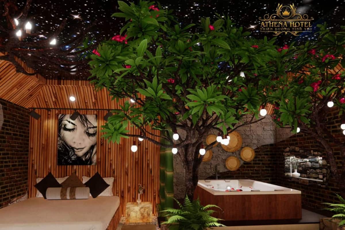 Une chambre avec un lit, un grand arbre, une baignoire et un plafond décoré d’un ciel étoilé.