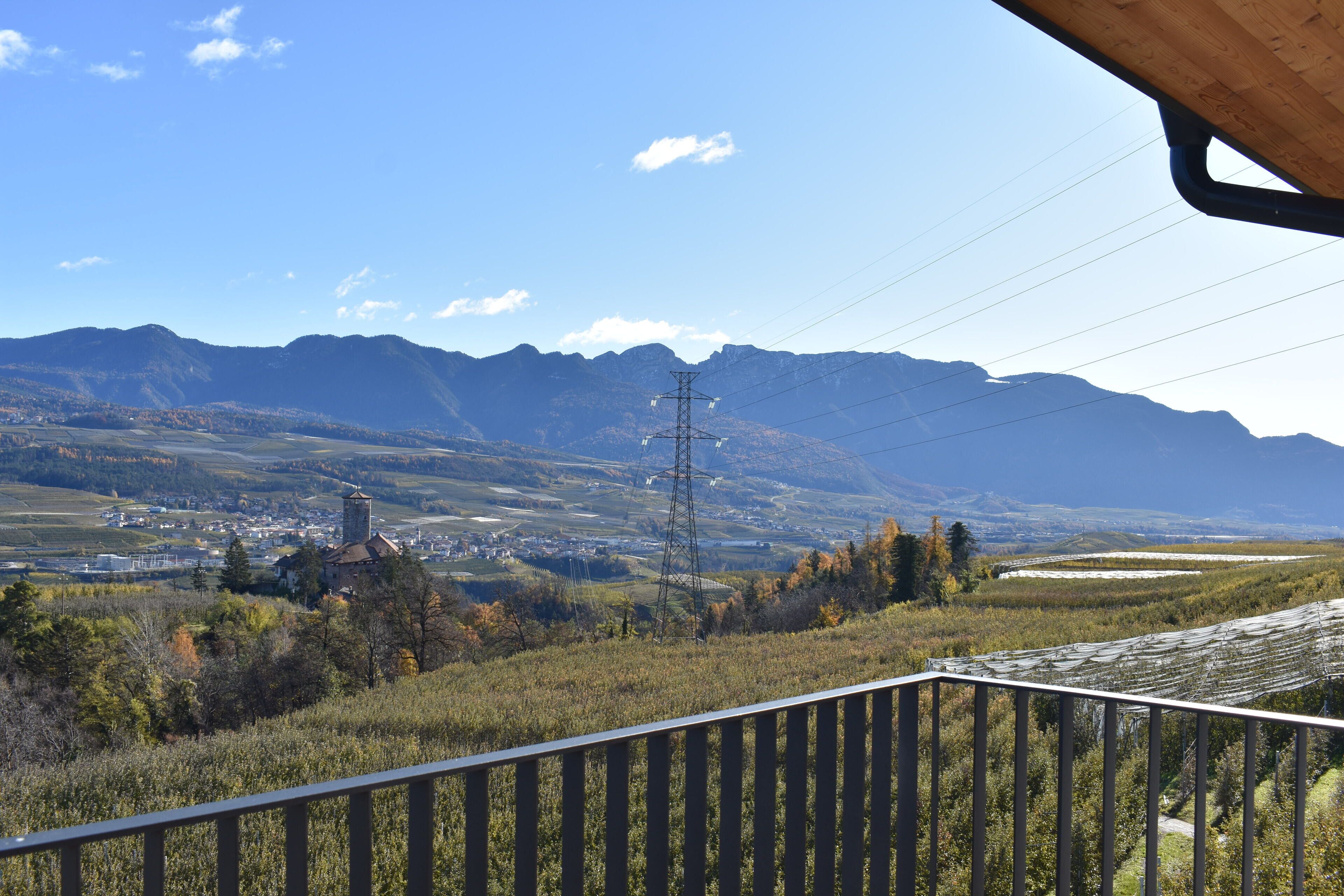A mountainous landscape with a town, power lines, and a wooden structure.