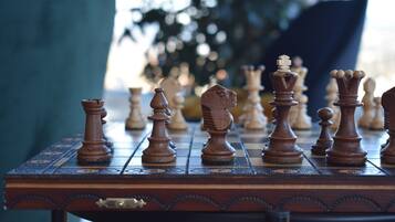 A chessboard with wooden pieces on a table.