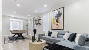 A modern living room with a grey sofa, a round coffee table, and a pool table. - Fun, Stylish, Pool table, Darts (Camden)