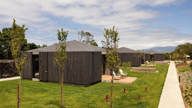 A modern building complex with multiple units, a well-maintained lawn, and a clear sky. - Batalha Golf Villas & Spa (Ponta Delgada)