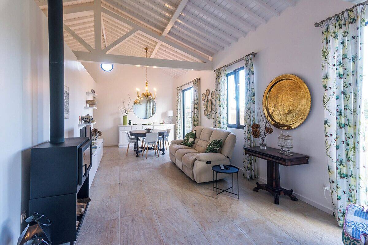 A spacious living room with a sofa, a dining table, and a fireplace.