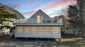Une maison de plain-pied avec un balcon, un garage et un petit porche.
