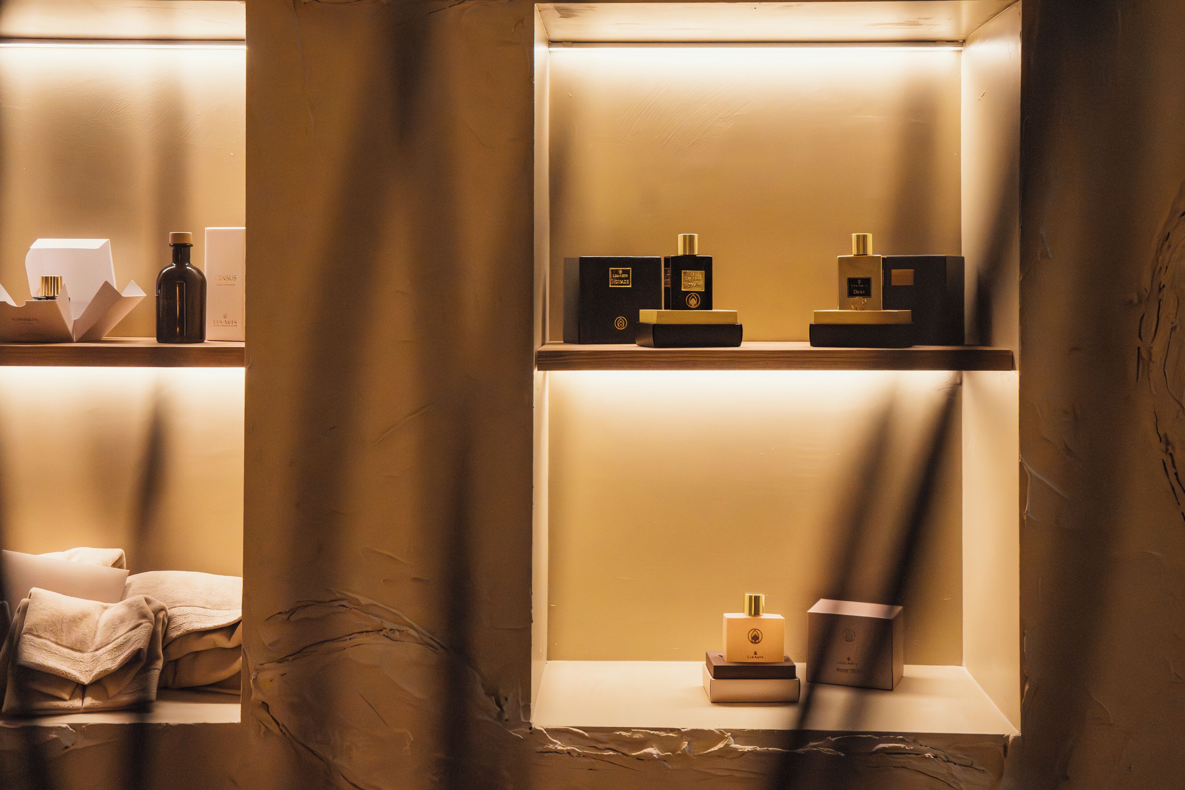 Una habitación de hotel con cama, mesita de noche y estante con artículos de aseo.