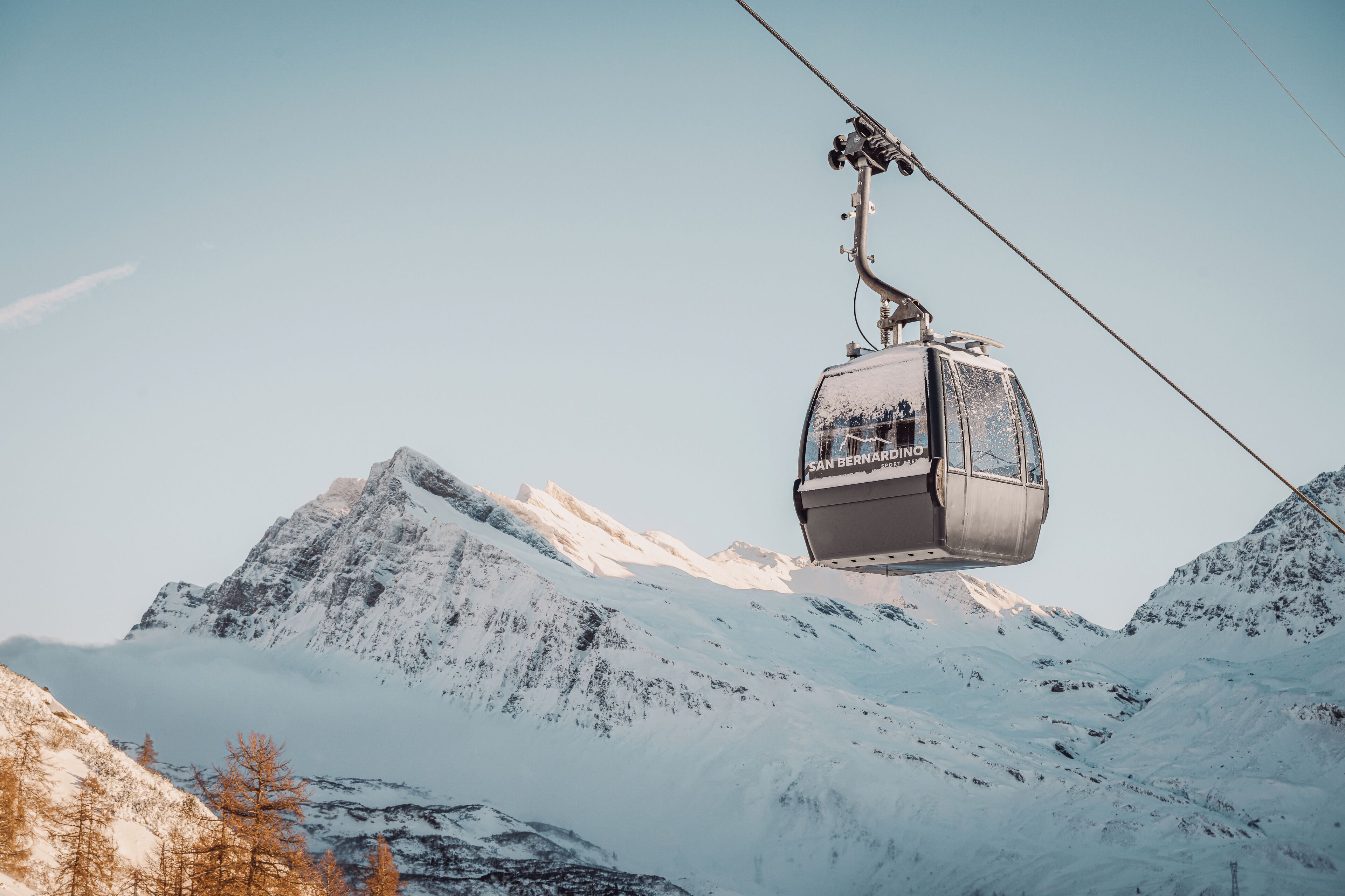 Un teleférico asciende un monte cubierto de nieve.