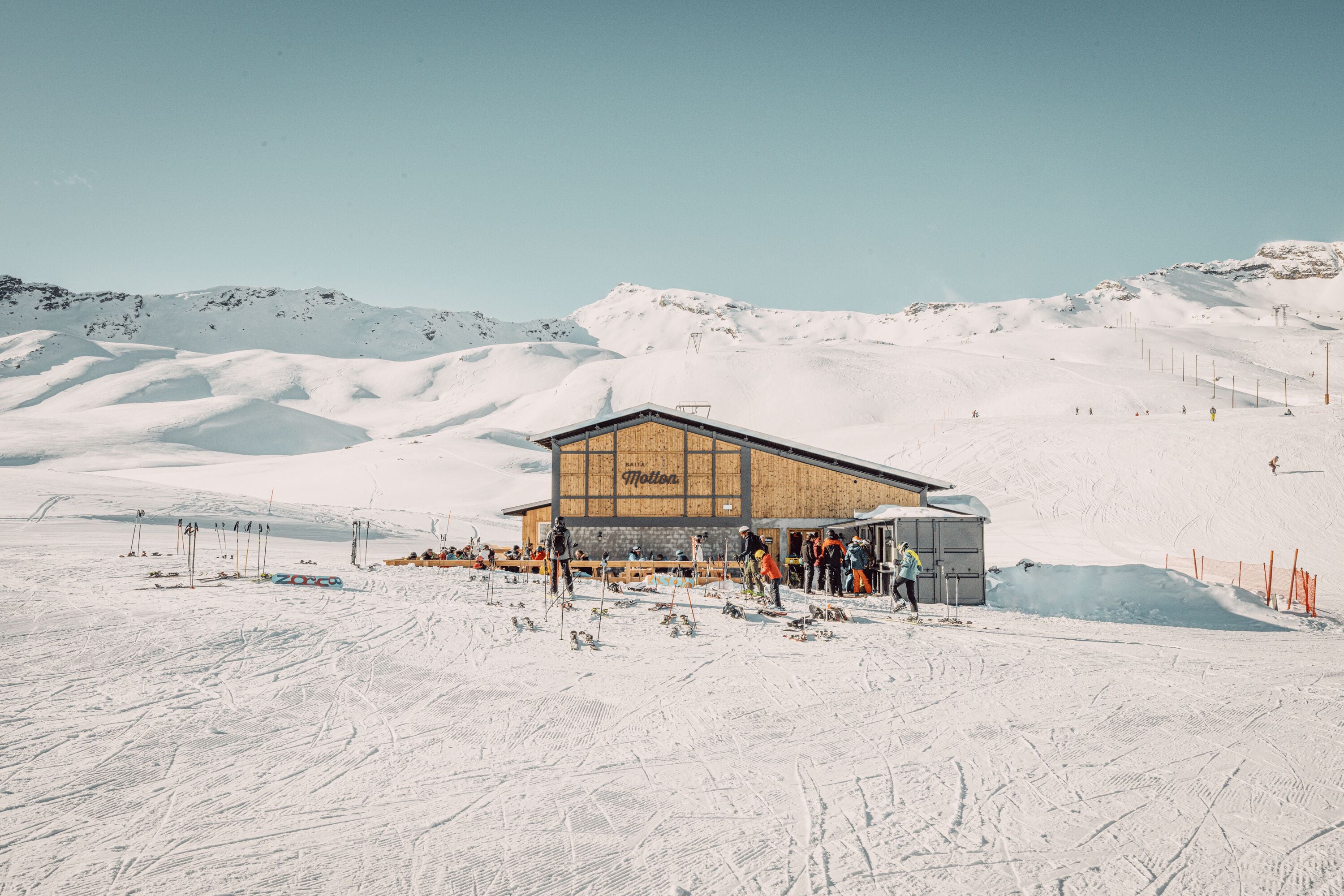 Ein Skigebiet mit einem Holzgebäude mit der Aufschrift "Motion" und einer Skipiste im Hintergrund.