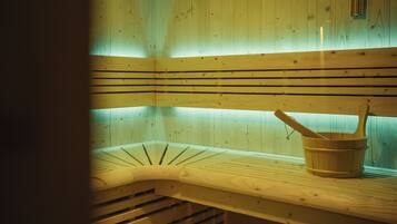 Uma sauna com bancos de madeira e um balde de madeira.