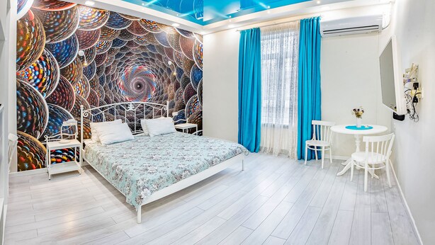 Een slaapkamer met een bed, een bureau en een stoel.