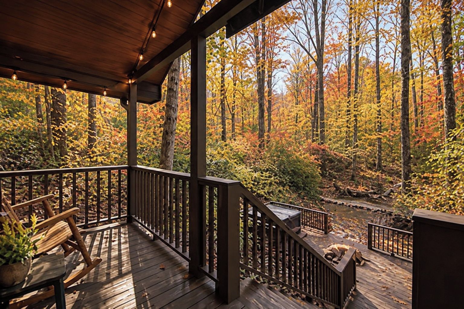 A wooden deck with a railing, a bench, and a potted plant.