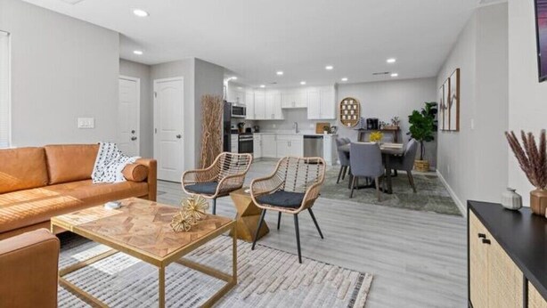 A modern living room with a sofa, two chairs, a coffee table, and a dining area with a table and chairs. - Wine Lovers Paradise (Lodi)