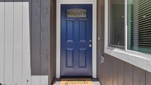 A blue door with a decorative top and a doormat that reads "WELCOME friends". - Wine Lovers Paradise (Lodi)