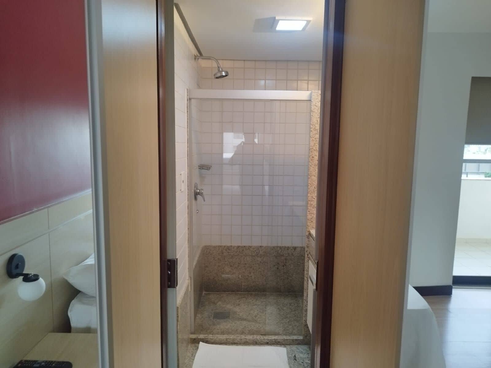 Une salle de bain d’hôtel équipée d’une douche, de toilettes et d’un lavabo.
