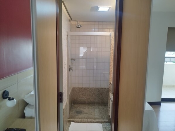 Un baño de hotel con ducha, inodoro y lavamanos.
