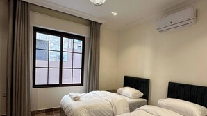 A hotel room with two beds, a large window, a ceiling light, and an air conditioning unit. - 3 Antica Jabalal-lwebdeh (Amman)