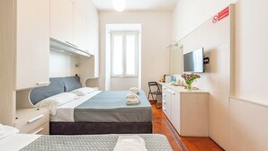 A hotel room with two beds, a desk with a TV, and a window. - Andenis Tiber House  (Rome)
