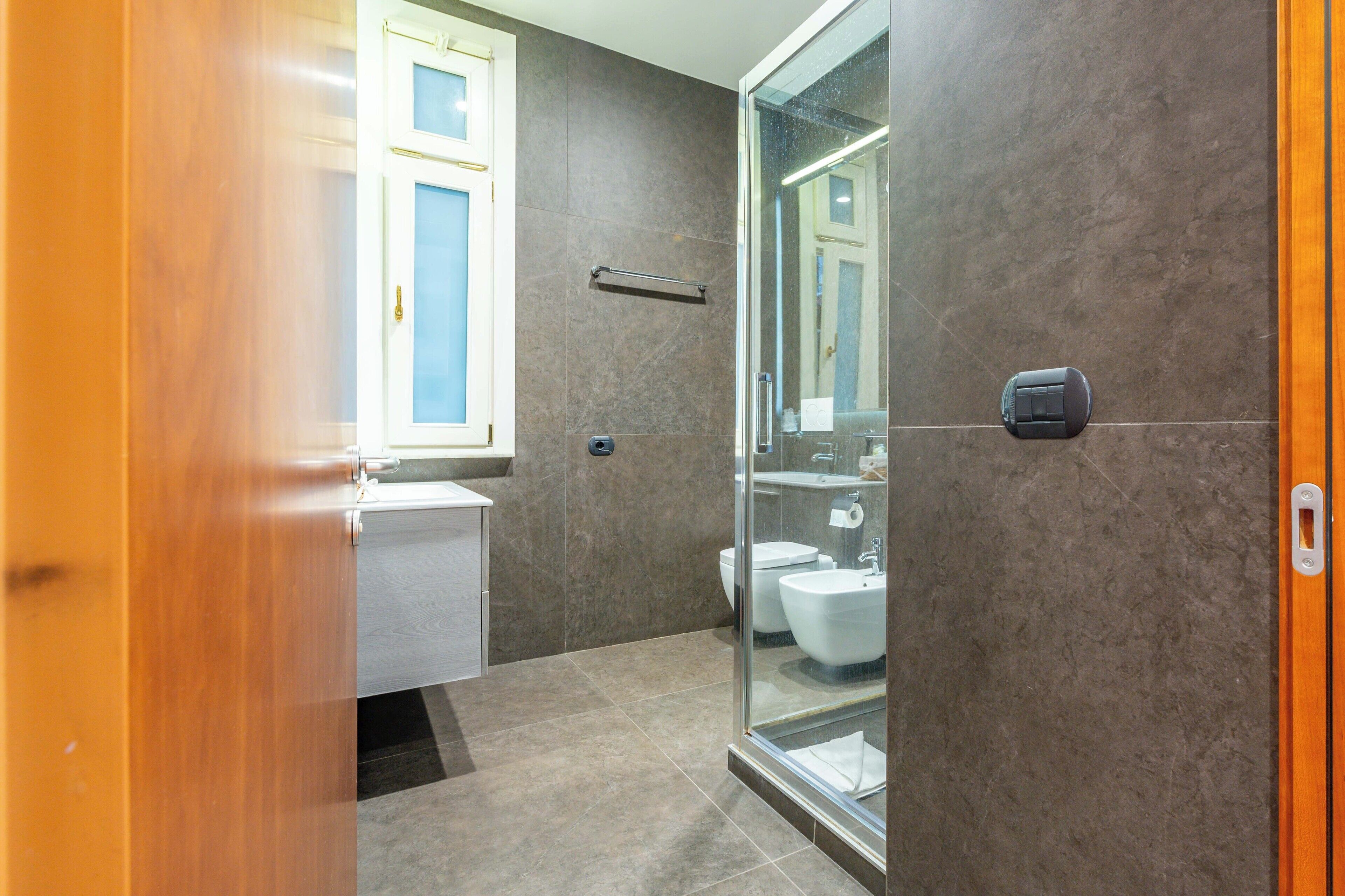 Ein modernes Badezimmer mit Duschkabine aus Glas, Toilette und Bidet.