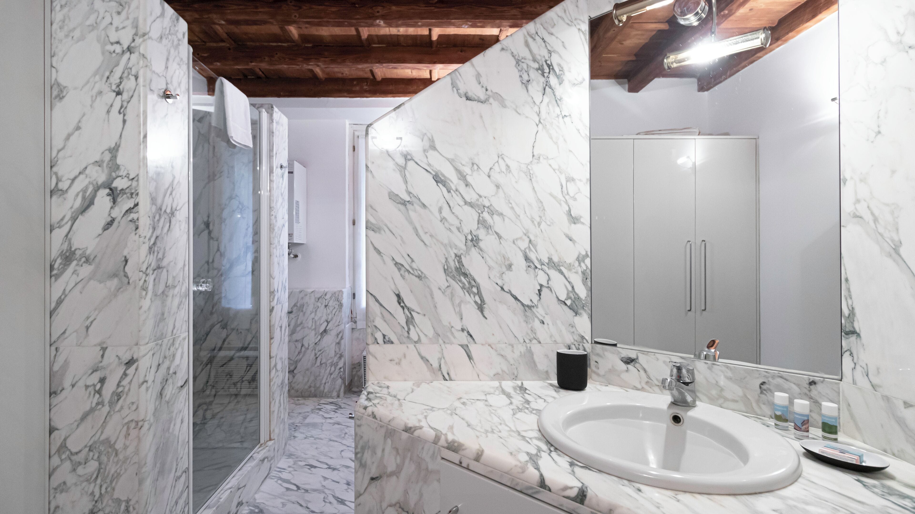 A bathroom with marble walls and a sink.