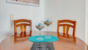 Un tavolo da pranzo con due sedie di legno, una fotografia incorniciata di una spiaggia, un cartello con la scritta 'welcome' e una targa con la scritta 'RENTALS'.