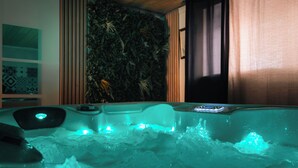 Un bain à remous doté d’un plafond en bois et d’un mur avec des lattes verticales.