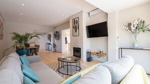 A modern living room with a sofa, coffee table, and a flat-screen TV mounted on the wall. - Ana- Beautiful villa in walking distance of Carvoeiro with Heated Private Pool (Carvoeiro)