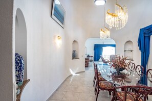 Enjoy meals in this elegant dining area with a long, oval-shaped table and comfortable seating.