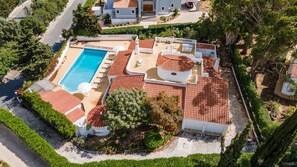 Relax in a villa with a pool surrounded by a beautifully maintained garden and outdoor patio.