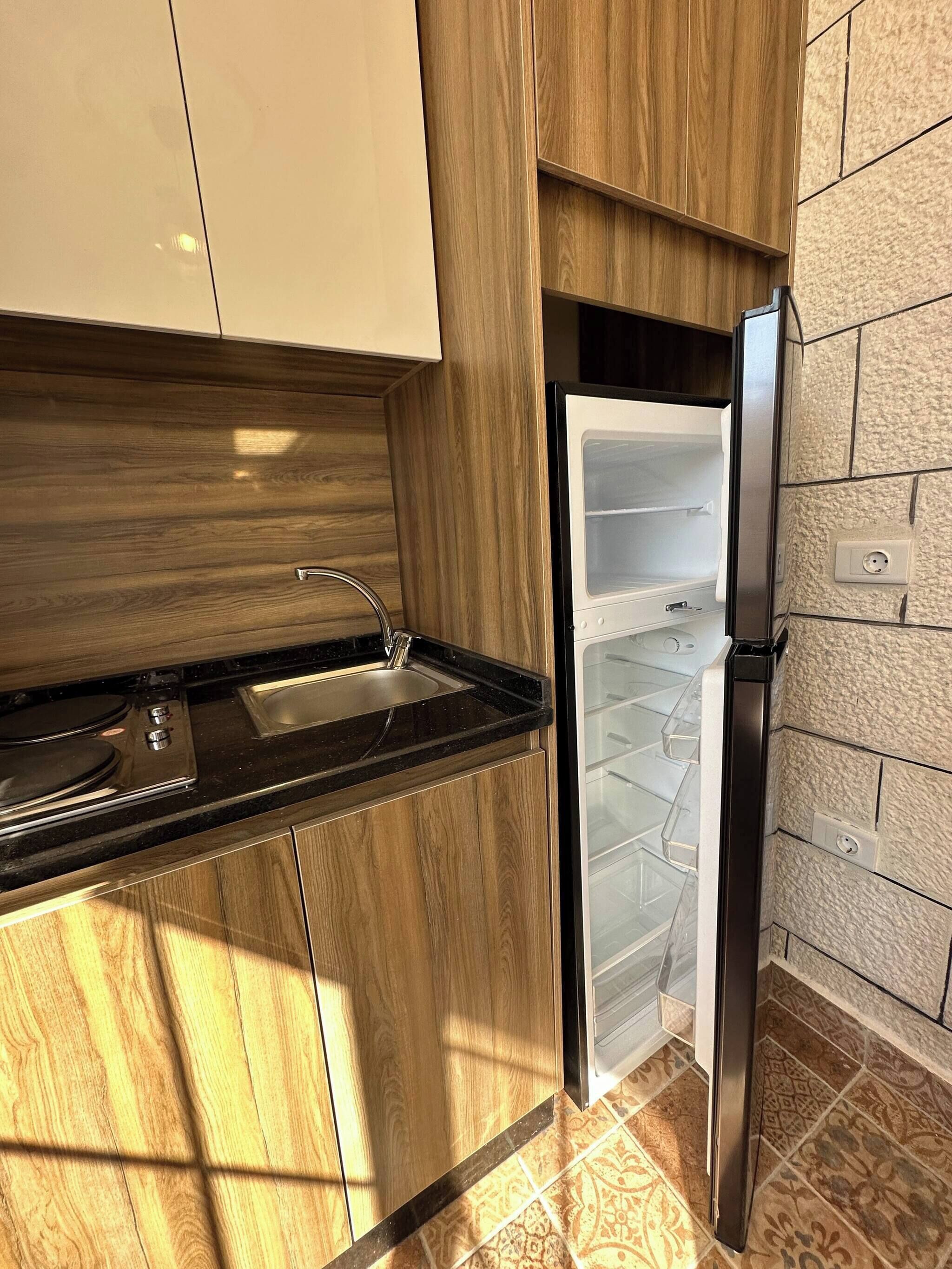 A kitchen with a built-in stove, a sink, and a refrigerator.