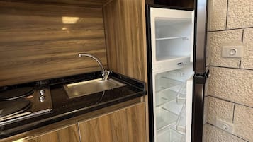 A kitchen with a built-in stove, a sink, and a refrigerator.