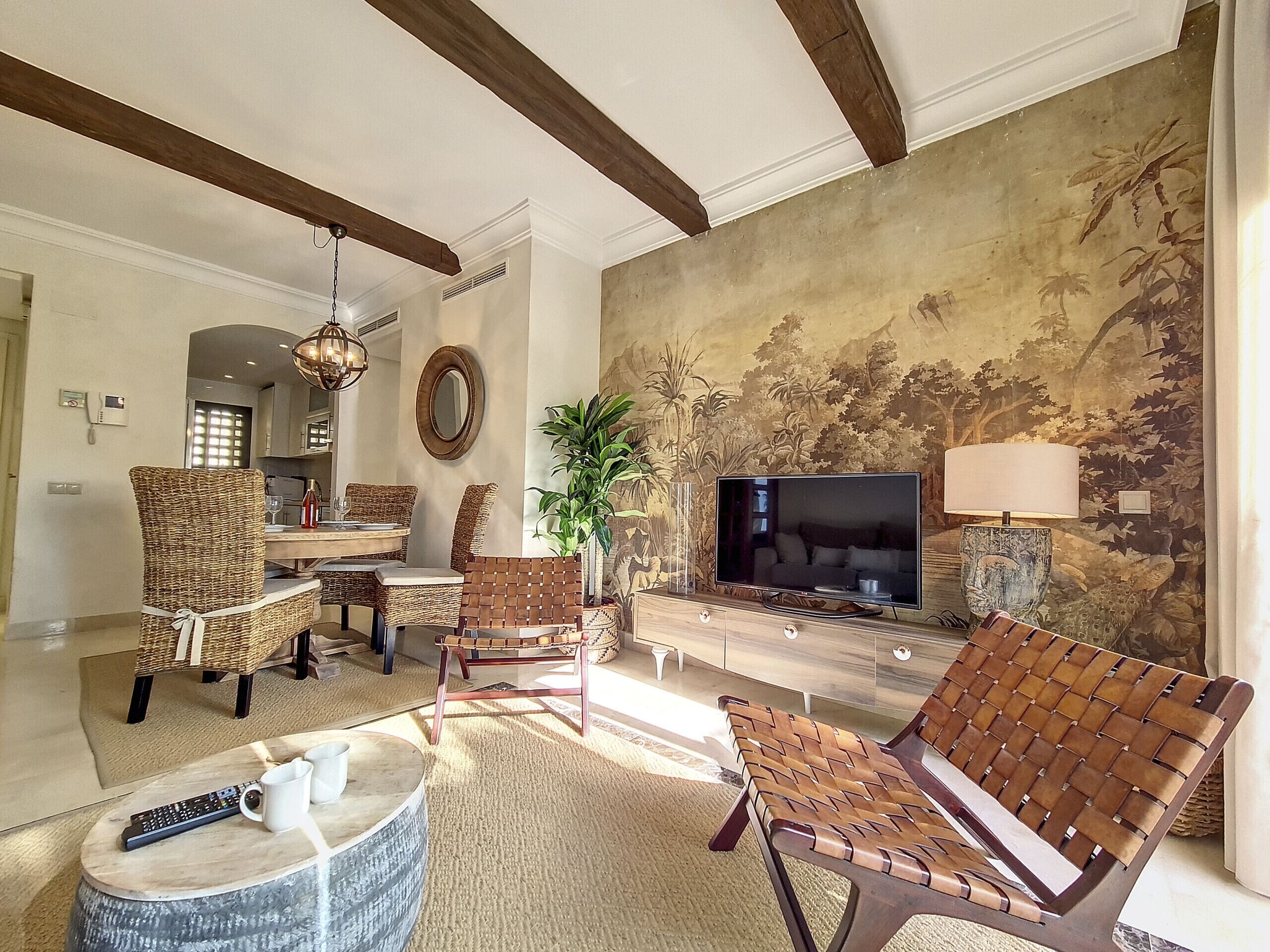A spacious living room with high ceilings, a large television, and comfortable seating.
