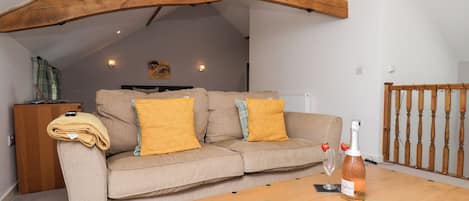 A cozy living room with a sofa, wooden coffee table, and a book.