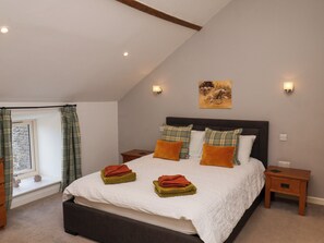 A bedroom with a bed, nightstands, a window with curtains, and a painting on the wall. - Hawthorn Cottage (Scarborough)