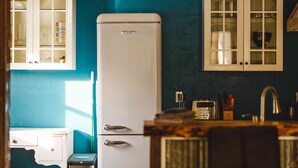 A kitchen with a white refrigerator, a sink, and cabinets. - Lakefront Farm, Tiny House, Sauna Experience - Pet Friendly! (Merville)