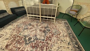 Ein Zelttyp-Zimmer mit einem Bett, zwei Sofas und einem gemusterten Teppich.