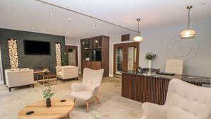 A modern living room with a fireplace, sofas, and a wooden coffee table.