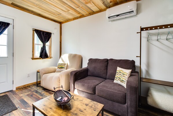 A cozy living room with a brown sofa, a beige armchair, and a wooden coffee table.