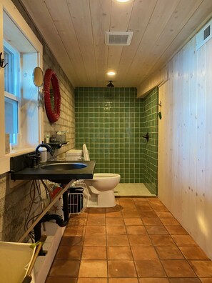 A bathroom with a sink, toilet, and shower area. - Rustic Lake Front Family Cabin with Beautiful Views (Carnelian Bay)