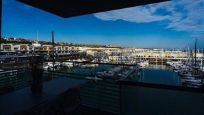 A marina with boats docked, a clear sky, and buildings in the background. - Marina with a view / 2 bd flat (Brighton and Hove)