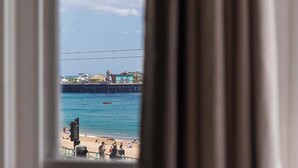 A view of a beach with a pier and a boat in the water. - Sea Breeze - 1 bedroom flat (Brighton and Hove)