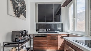 Eine moderne Küche mit integriertem Geschirrspüler, Holzschränken und einem großen Fenster für natürliches Licht.