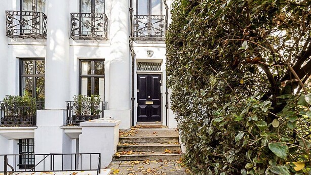 A building with a black door, white walls, and a balcony with wrought iron railings. - Beautiful One-Bedroom Apartment In Notting Hill (London)