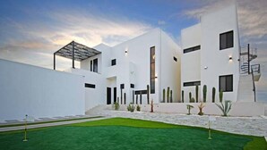 A modern building with a flat roof, multiple windows, and a staircase leading to an upper level. - Unique Unit-Private Pool,Isla Espiritu Santo VIEW! (La Paz)