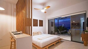 A modern bedroom with a bed, a desk, and a view of the outdoors. - Unique Unit-Private Pool,Isla Espiritu Santo VIEW! (La Paz)